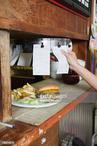 Burger and order tickets on a diner counter